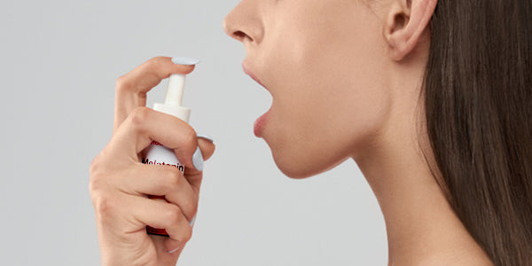 Frau sprüht nu3 Redcare Melatonin-Spray in den Mund