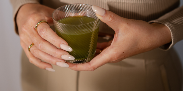 grüne Flüssigkeit im Glas in der Hand