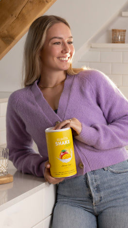 lächelnde Frau mit einer BEAVITA Dose in der Hand