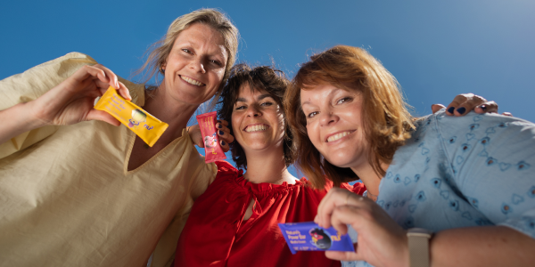 drei Frauen mit drei bunten Riegeln in der Hand