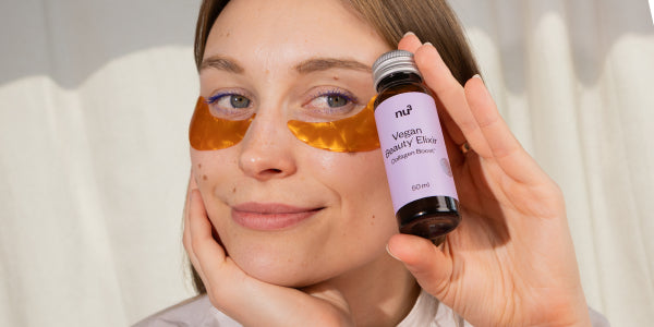 Frau mit Vegan Beauty Elixir Fäschchen in der Hand
