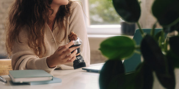 Frau snackt Fit Protein Bar am Schreibtisch