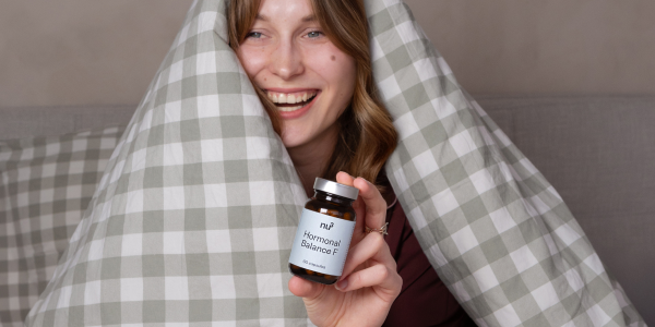 Frau unter der Decke mit Hormonal Balance F kapseln