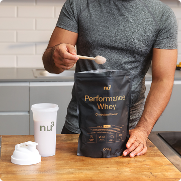 Mann füllt einen Scoop nu3 Performance Whey in Shaker