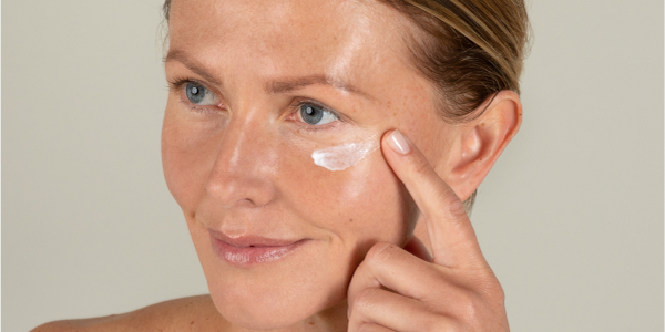 Frau mit schöner Haut und Augencreme