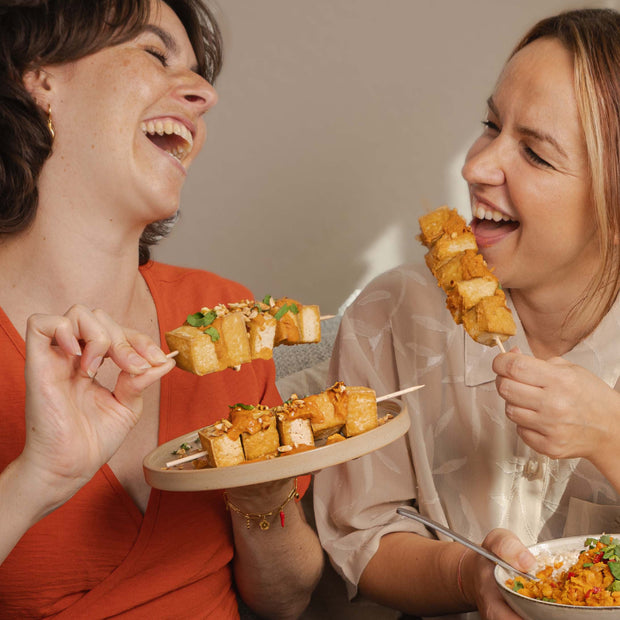 2 Frauen, die Tofu-Spieße essen