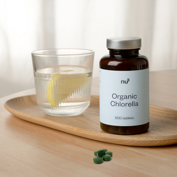 Chlorella-Tabletten mit Glas Wasser zum Einnehmen