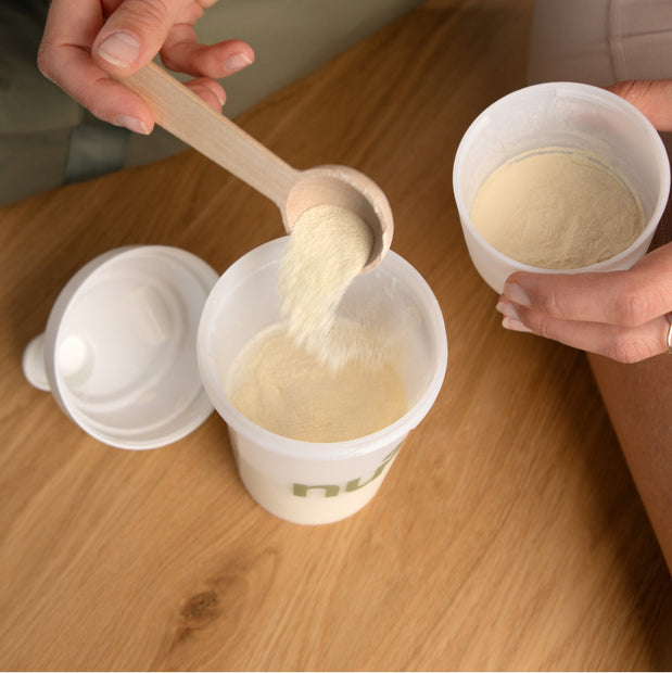 Pulver wird mit Messlöffel in Shaker gegeben