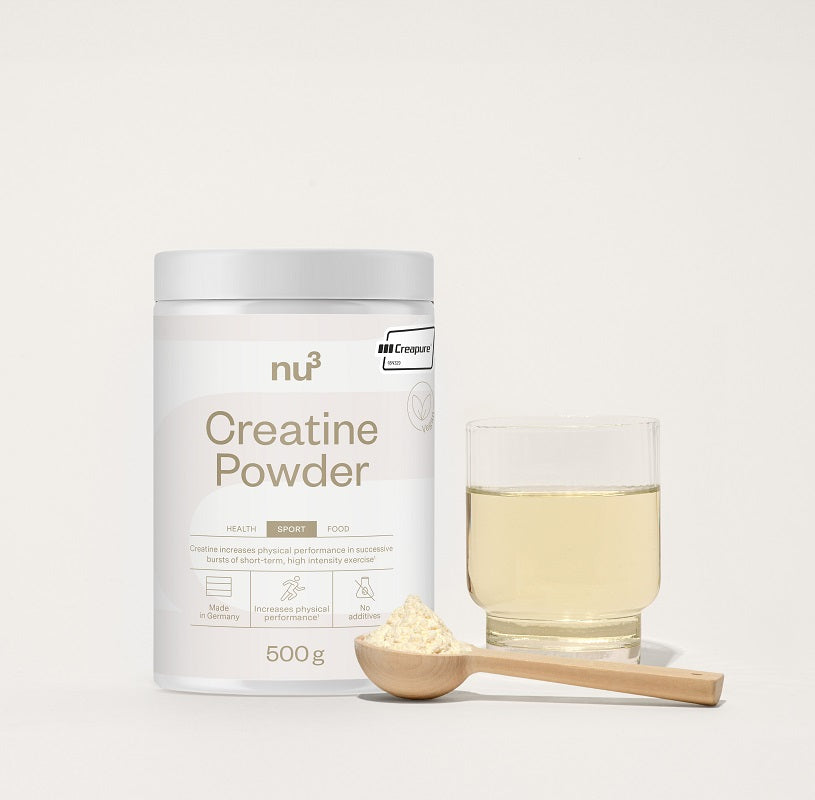 Verpackung und Glas mit Creatine Pulver plus Holzlöffel