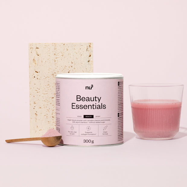 Beauty Essentials mit Löffel und Glas vor Stein und rosa Hintergrund