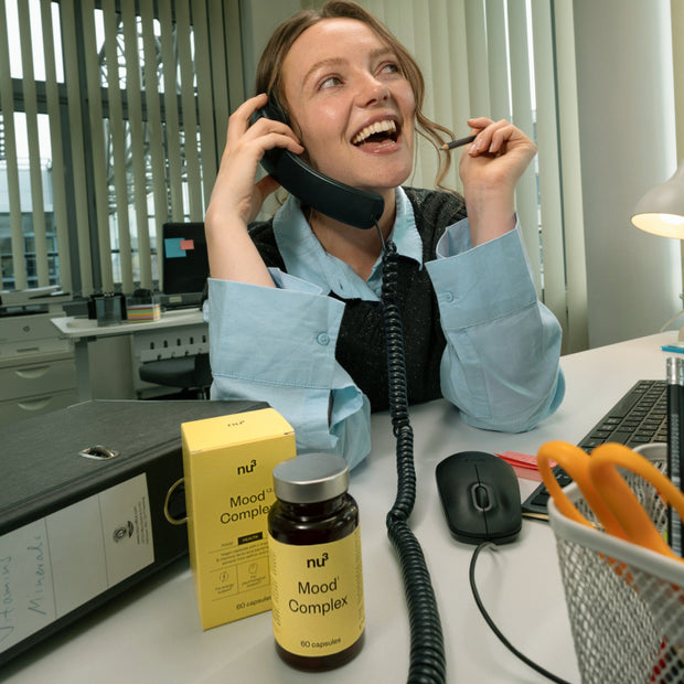Frau am Telefon mit Mood Komplex auf dem Schreibtisch