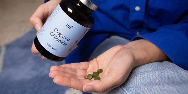 Hand hält Chlorella Tabletten